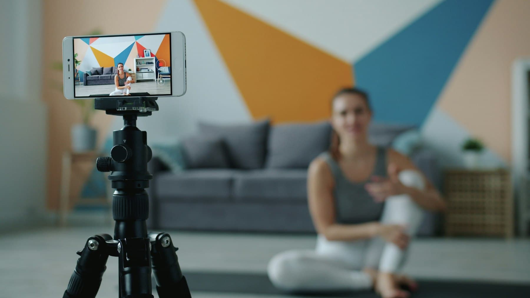 A phone on a tripod set up to film in a living room